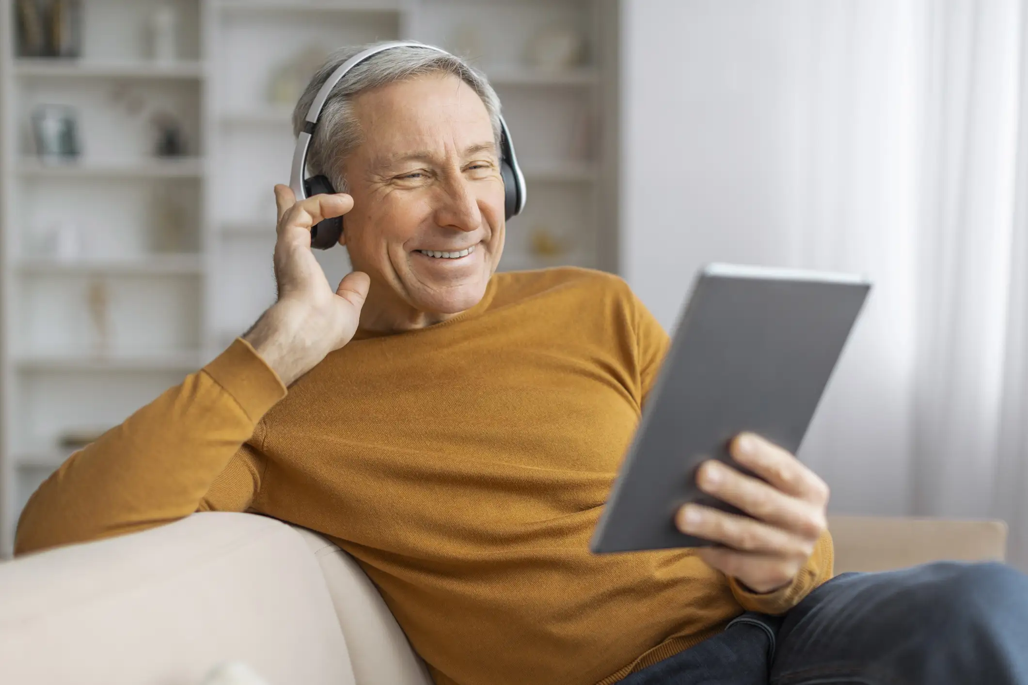 Senior man listening to an audiobook an Senior man listening to an audiobook an