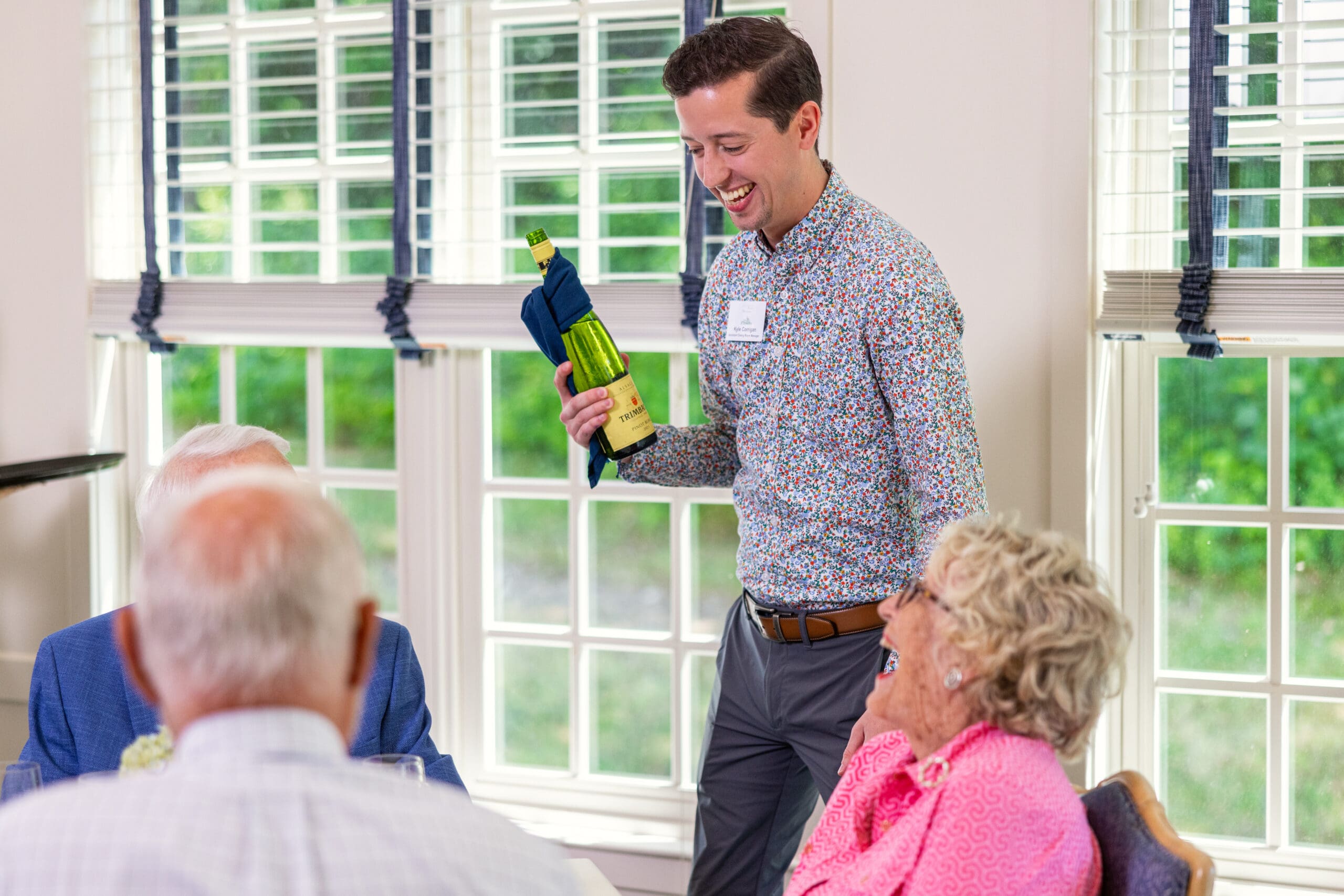 A Waiter serving residents with wine and getting ready to take orders of resident's favorite meals at Essex Meadows, a retirement community in CT. A Waiter serving residents with wine and getting ready to take orders of resident's favorite meals at Essex Meadows, a retirement community in CT.
