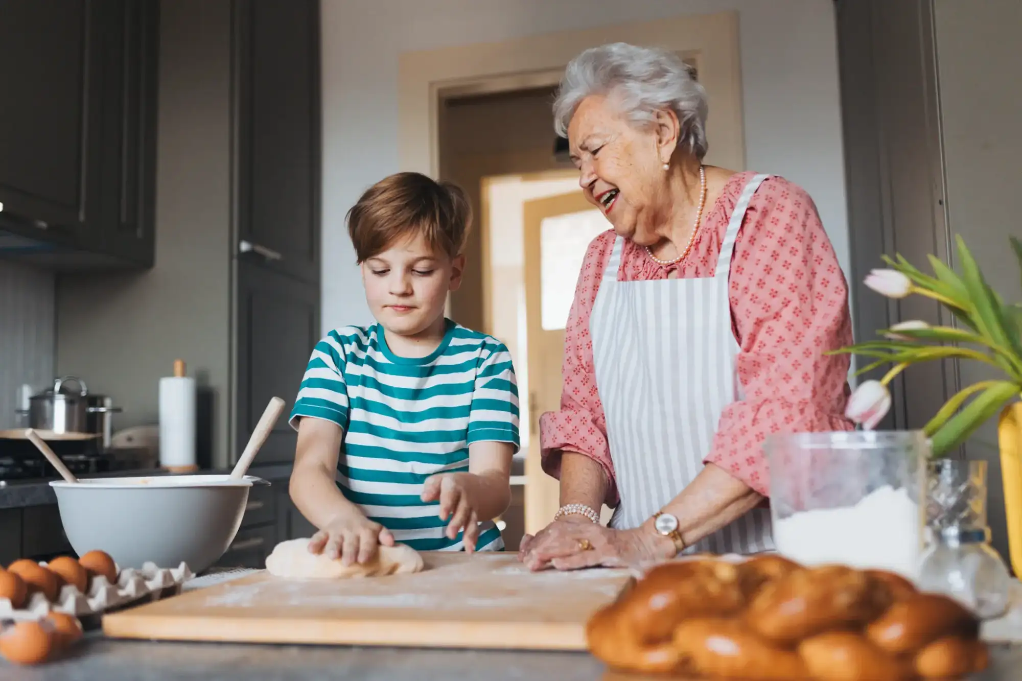 Grandmother with grandson preparing a meal, a perfect activity for seniors with limited mobility.