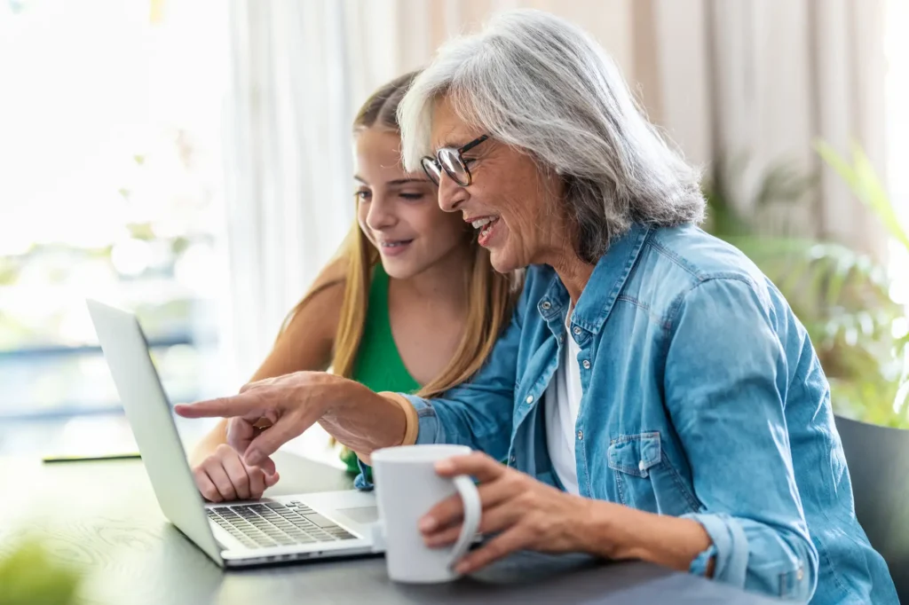 grandmother and grandchild on laptop looking at multigenerational summer activities in Essex, CT.