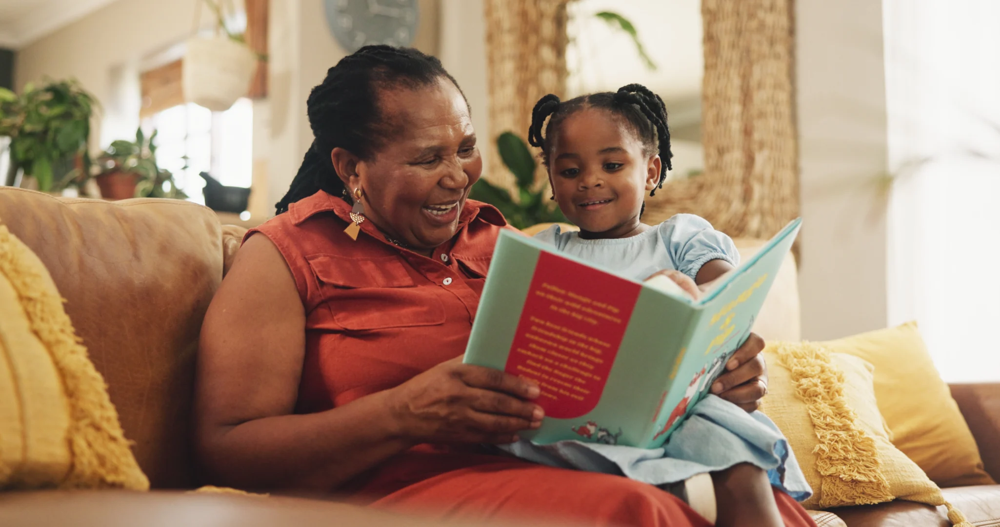 A grandmother and granddaughter reading a book as one of the many multigenerational summer activities you can enjoy